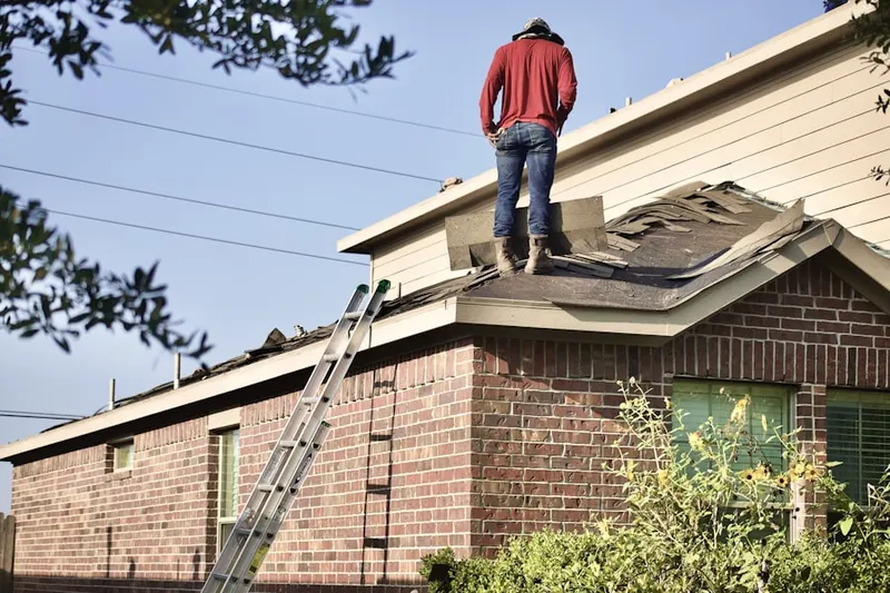 Professional roofer working on a residential roof in Amityville